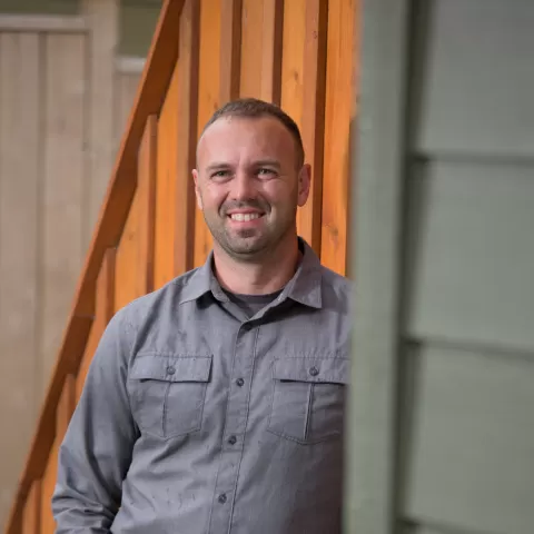 Rob Avis leaning against the corner of the house.